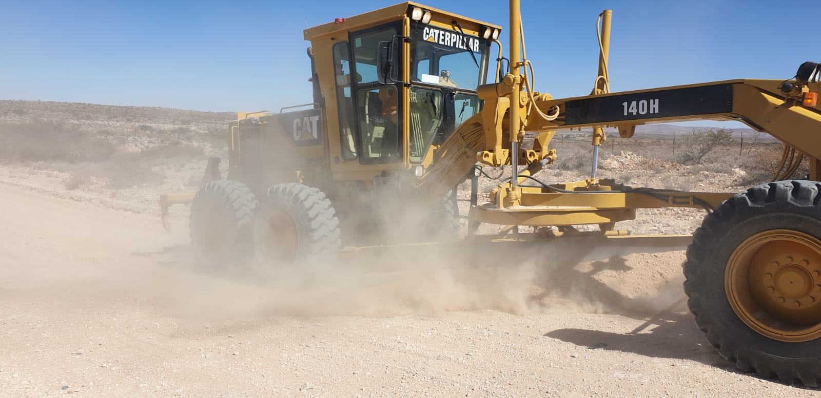 Caterpillar grader shaping and maintaining a gravel road